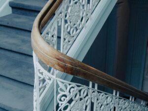 Wooden handrail and ornate iron banister on a period staircase in a West London leasehold property.